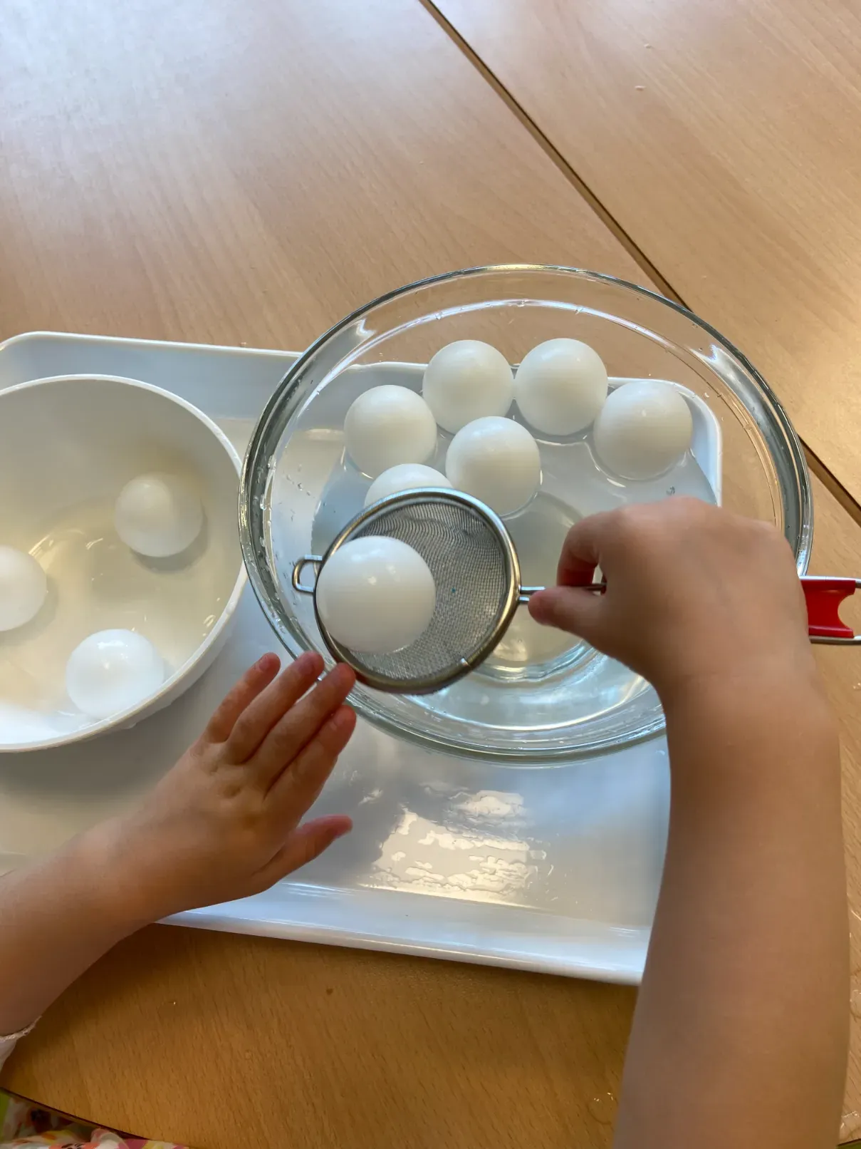 Kind schöpft Eier ab