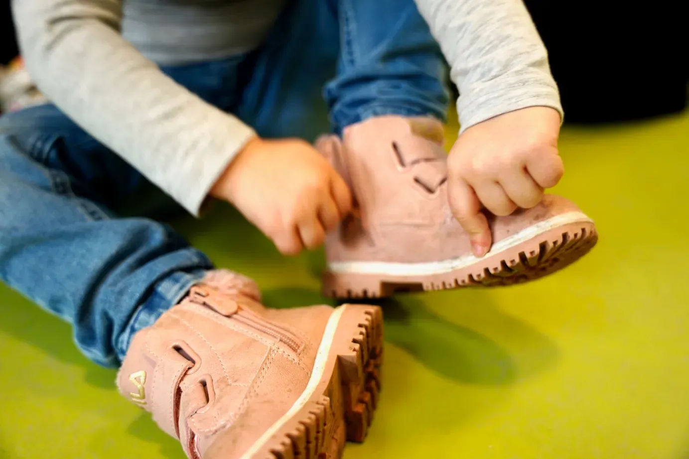 Kind zieht sich die Schuhe an