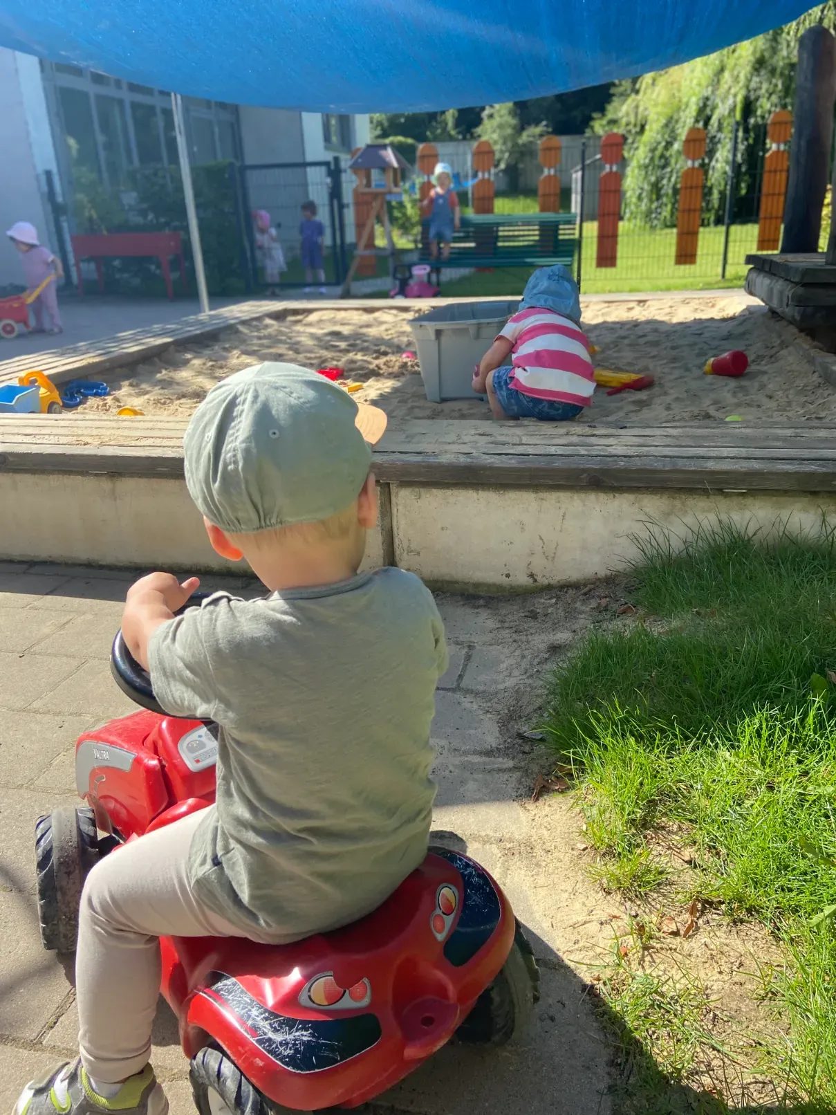 Kinder spielen draußen im Garten des Kinderhauses